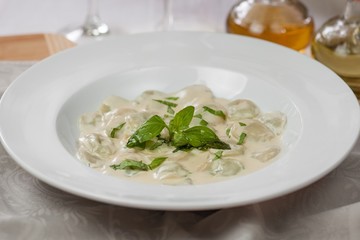 meat dumplings with basil on a white plate
