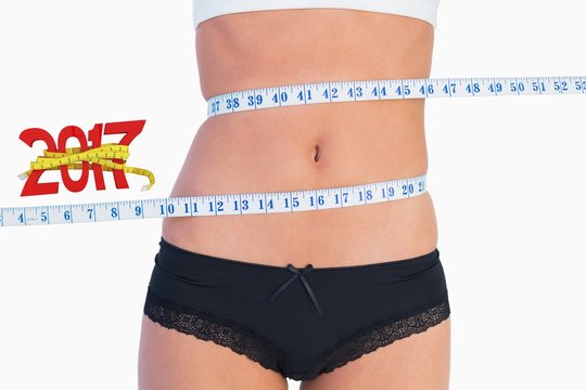 Composite image of slim belly surrounded by measuring tape