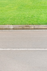 Fototapeta premium Part of an asphalt road with a border and a green lawn