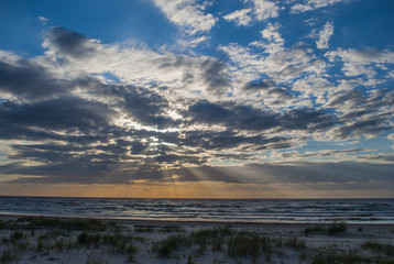 Sunset on seashore with light rays 