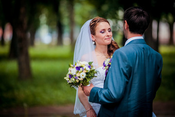 Elegant bride and groom posing together outdoors on a wedding day