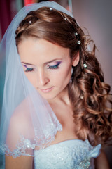 Portrait of beautiful bride. Morning of the bride. Wedding morning. Makeup. girl with long wavy hair.