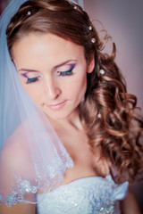 Portrait of beautiful bride. Morning of the bride. Wedding morning. Makeup. girl with long wavy hair.