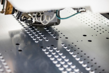 Rotation CNC Punching & Nibbling Machine in action. Metal perforating industrial machine.