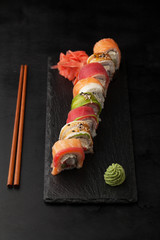  Sushi Roll with avocado, salmon, tobiko, tuna and eel on a blac