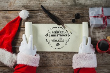 Composite image of close-up of santa claus opening scroll