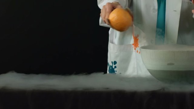 Frozen in liquid nitrogen. A hammer smashing orange frozen in liquid nitrogen. Slow motion
