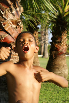 Boy Sitting Under Palm.