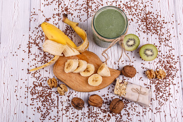 healthy green smoothie with walnut and fruits lie on the table