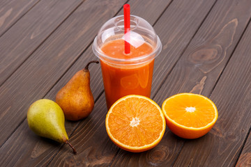 orange detox coctail with oranges and pears lies on wooden table