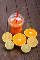 orange detox coctail with half orange,lemon and lime lies on tab