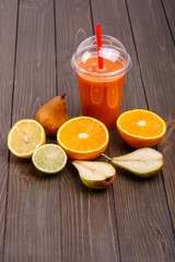 Obraz na płótnie Canvas orange detox coctail with half orange,lemon,pear and lime lies o