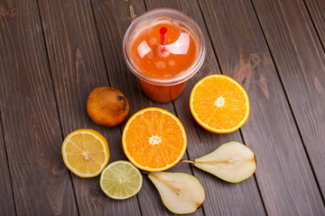 orange detox coctail with half orange,lemon,pear and lime lies o