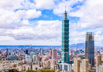 Naklejka premium Aerial panorama over Downtown Taipei, capital city of Taiwan with view of prominent Taipei 101 Tower amid skyscrapers in Xinyi Financial District & overcrowded buildings in city center under sunny sky