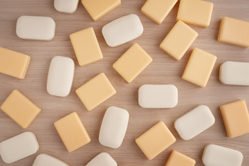 Pieces of soap on a wooden background. Soap of different colors can be seen from above. Soap is needed to maintain health.