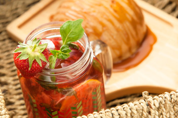 bread drizzled with honey on a wooden plate and a glass with a cocktail in a wicker basket