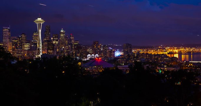 Seattle, Washington, USA - illuminated skyline of Seattle with Space needle, harbor and Elliott Bay - view from Kerry Park at sunset with moving clouds - Timelapse with motion