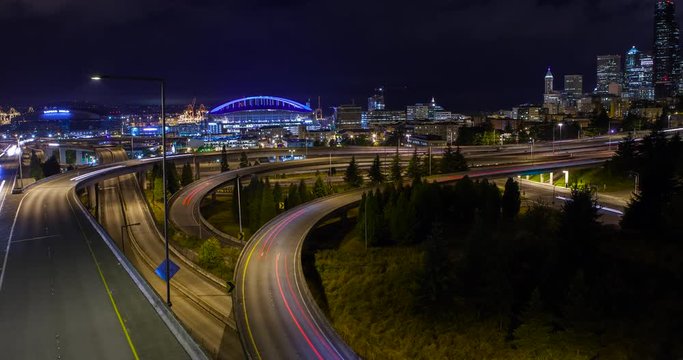 Seattle, Washington, USA - illuminated skyline with CenturyLink Field and Safeco Field as seen from Dr. Jose Rizal Park with Interstate 5 and 90 Express at night - Timelapse with motion 