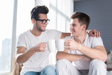 Homosexual couple having a hot drink together.