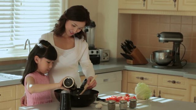 MS Mother and daughter cooking in kitchen / China