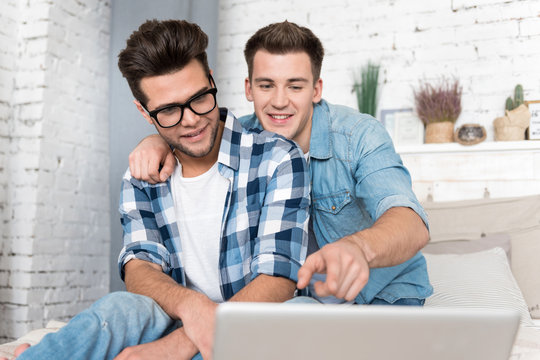 Handsome male partners of non traditional orientation using a laptop