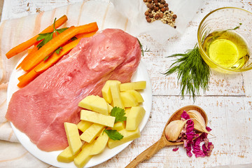 Raw turkey breast with spices on plate and spices over rustic table. Rustic stile