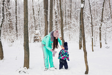 Fototapeta na wymiar Mother and child playing with snow outdoors