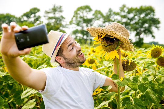 Man makes selfie in the field of sunflowers