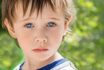 Little boy with beautiful blue eyes looking sad, frustrated