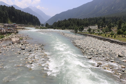Beautiful scenic Lidder river flowing through Pahalgam Valley in Jammu & Kashmir. People enjoying here around the world.
