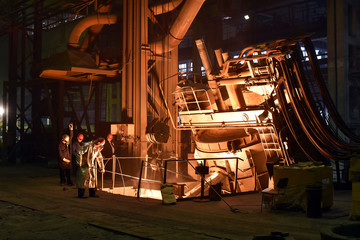 Arbeiter in einer Industrieanlage: Abstich am Hochofen einer Giesserei // Worker in an industrial plant: tapping at the blast furnace of a foundry - obrazy, fototapety, plakaty