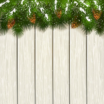 Christmas fir tree branches with snow and cones on white wooden