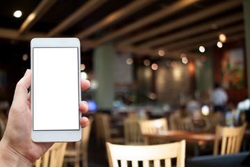 Business conceptual- Focused on left hand holding mobile with restaurant blurred background