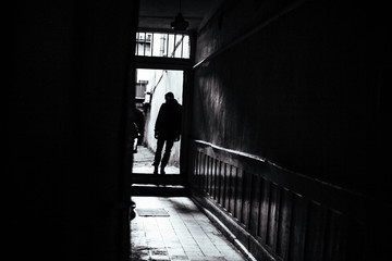 Obraz na płótnie Canvas young man in a black coat standing near open doors