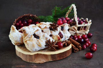 Christmas sweet puff braided pastries,Croissant with cranberry jam filling on vintage wooden tray. Winter Dessert with flavored spices, fresh berries. Holiday picture in a dark way.