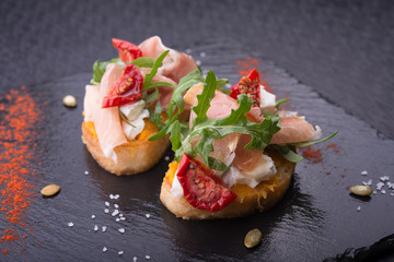 delicious bruschetta with prosciutto, tomatoes