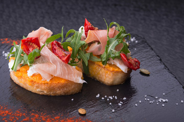 delicious bruschetta with prosciutto, tomatoes