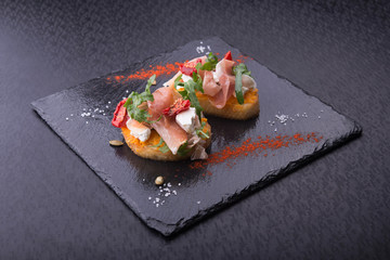 delicious bruschetta with prosciutto, tomatoes
