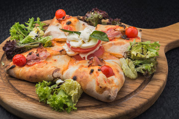 italian pizza calzone with tomato, salad and mozzarella