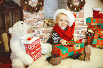 Happy little boy opening Christmas presents.