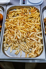 Steel container with roasted french fries potato wedges