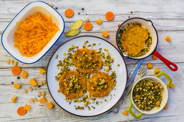 Fried fritters with pumpkin with fried sprouts and spices on wooden background. Vegetarian food.
