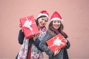 Happy Christmas and happy new year! Multiracial girls showing Christmas gifts.