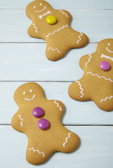 Hand decorated gingerbread men on a painted wooden table background 