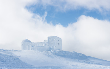 Winter landscape with the old observatory in the mountains
