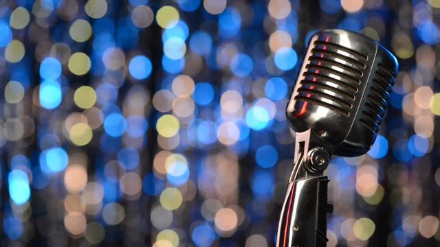 Closeup of retro microphone with blurred lights at background