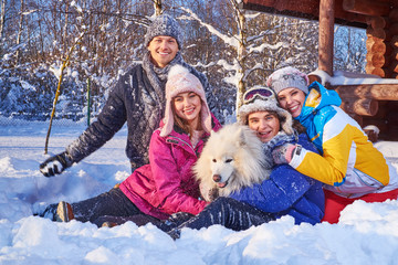 Cheerful friends with dog spend winter holidays together at mountain cottage