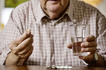 Senior nimm seine Meikamente ein, Tabletten, Medizin