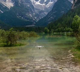 Fototapeta na wymiar Drone flying over mountain lake. Alps, Italy.
