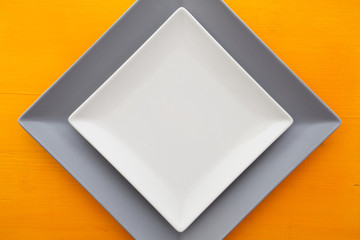 Empty white ceramic dish on over orange wooden table